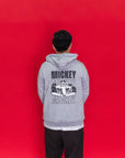An adult wearing an Adult Carey Mickey Hoodie - Grey hoodie with a large Mickey Mouse in a racing car graphic on the back