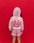 A child wearing a Minnie Mouse pink hoodie with a large red and white checkered bow graphic and 'Racing Sassy Series' text on the back.