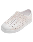 Angled view of white iridescent casual slip-on shoes with perforated upper and rounded toe