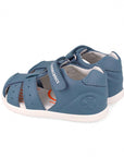 Blue children's sandal with white sole on a white background