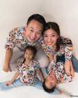 Family of four wearing matching pop comic mickey tees on a white background.