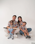 Family of four wearing matching pop comic mickey tees on a white background.
