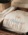 Personalisable name embroidery on bamboo muslin swaddle blanket with "oliver" in light blue thread title case
