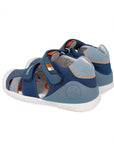 Blue children's sandal with orange accent and white sole on a white background