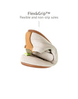A Tapioca and green baby sneaker folded to show the Flex&Grip non-slip, ultra-flexible rubber sole.