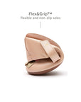 A pink baby shoe folded in half to show the Flex&Grip ultra-flexible, non-slip sole.