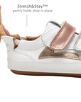 Close-up of the Stretch & Stay elastic heel and rose gold accent on the Landy baby sneaker for easy dressing.