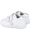 White children's shoes with velcro straps on a white background