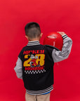 A child shown from the back wearing a black and gray Bomber Jacket - Mickey 28 varsity jacket with a large Mickey Mouse embroidery on the back.