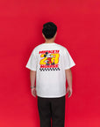 A man viewed from behind wearing a white Mickey Mouse graphic T-shirt with a large red, yellow, and black back print.
