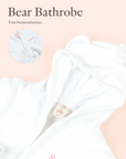 Close-up of personalised white Bear bathrobe embroidery detail on soft neutral background