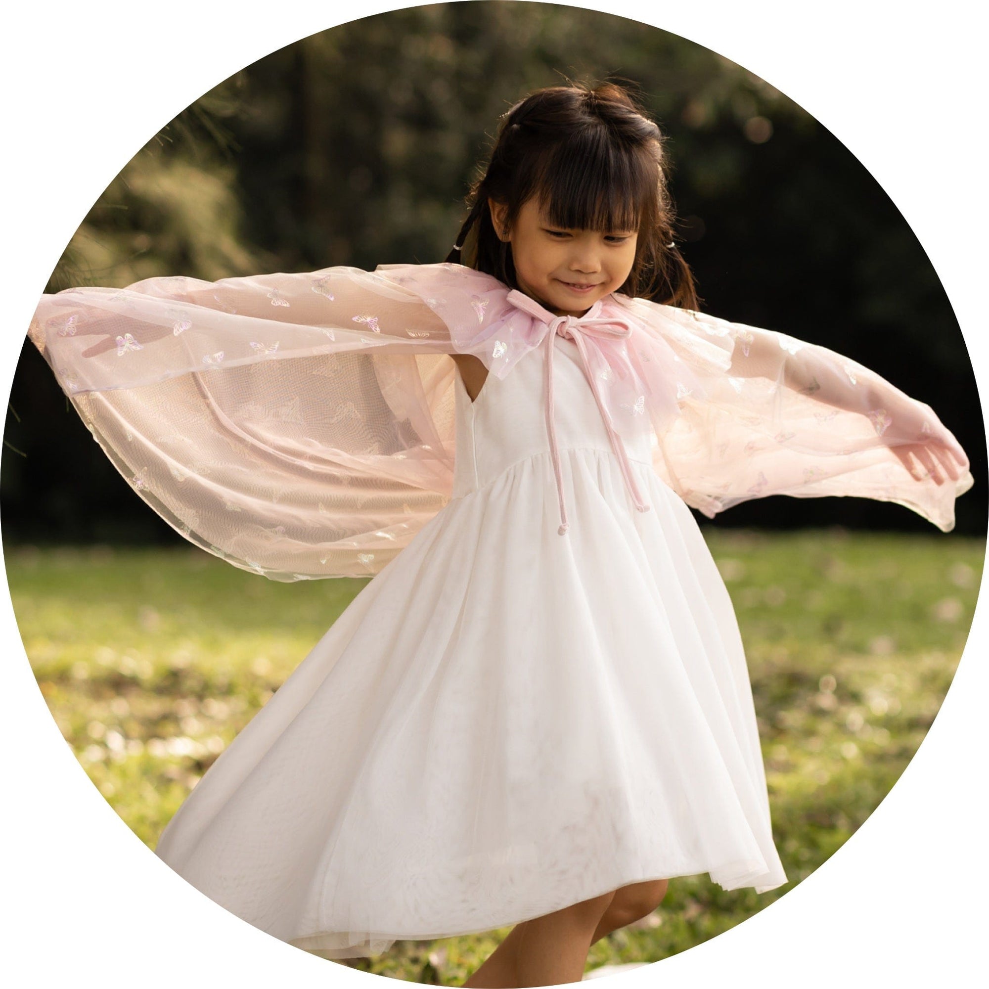Girl in white dress with pink cape