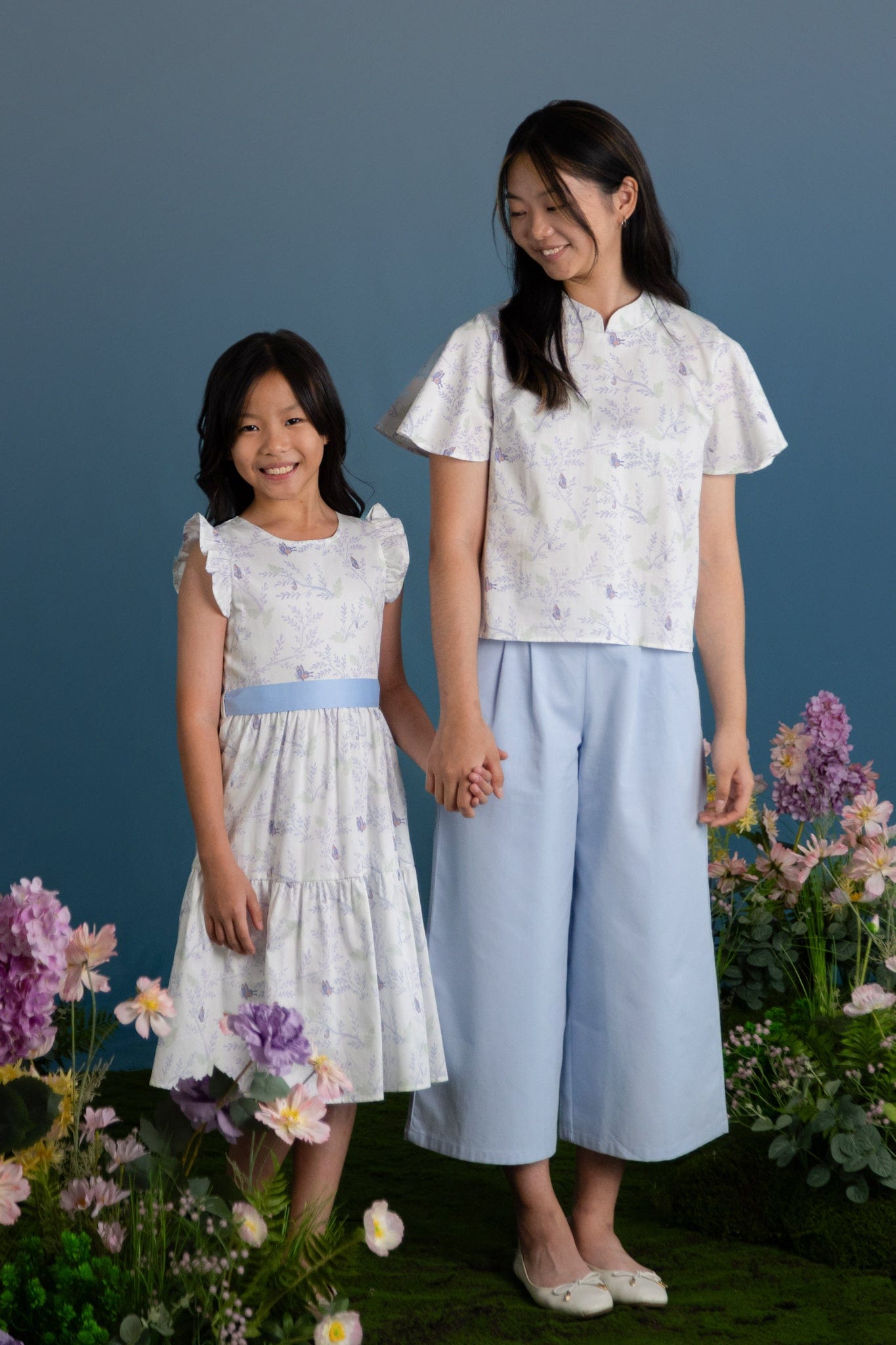 Two girls wearing matching floral outfits