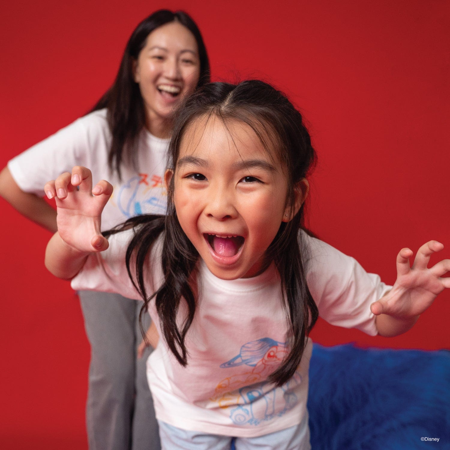 Mother and daughter smiling, wearing Stitch t-shirts.