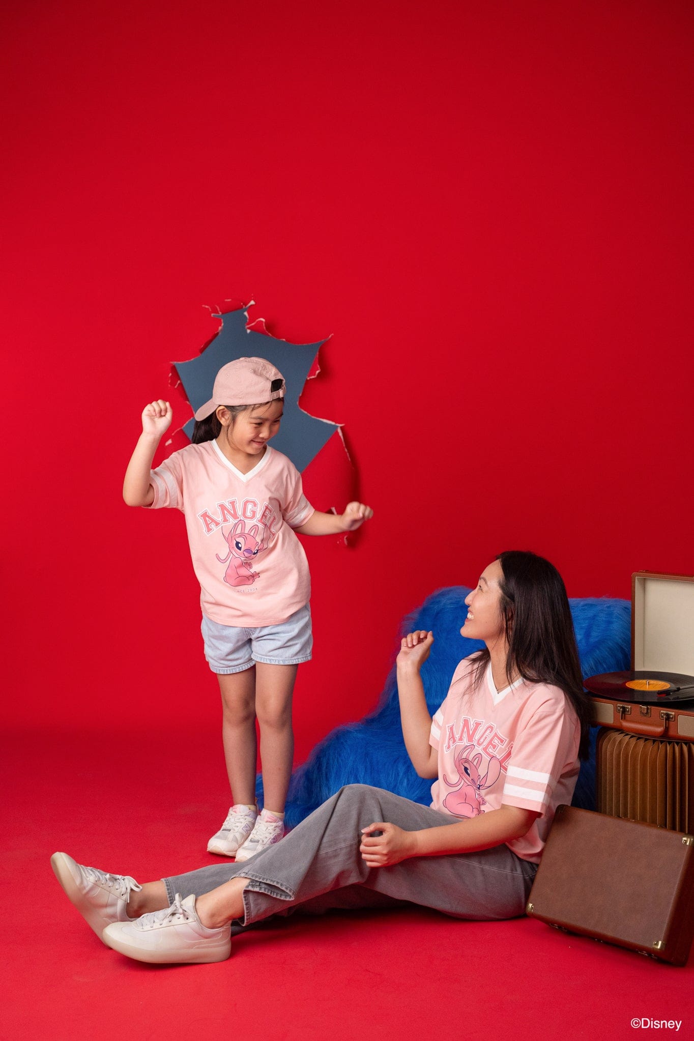mother and child in front of red backdrop