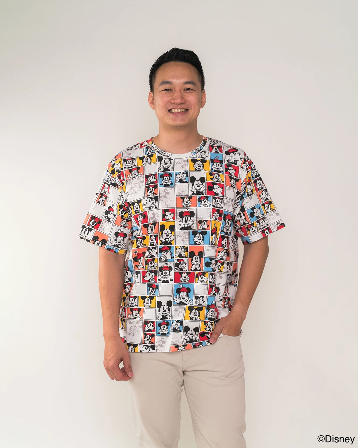 Man wearing adult tee in pop comic mickey design with a plain background