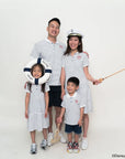 Family of four wearing matching stripes sailor mickey outfits with a white background