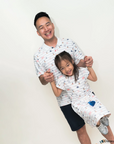 Man and young girl wearing matching nautical mickey outfits  against a white background
