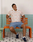 Full body shot of the Elly Men's Childhood Games Polo Tee with blue shorts.