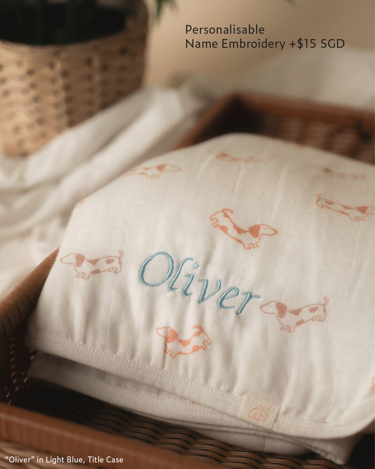 personalisable name embroidery on muslin swaddle with "Oliver" in Light Blue title case 
