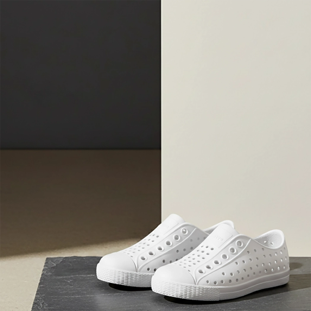 White slip-on shoes on a gray surface with a neutral background