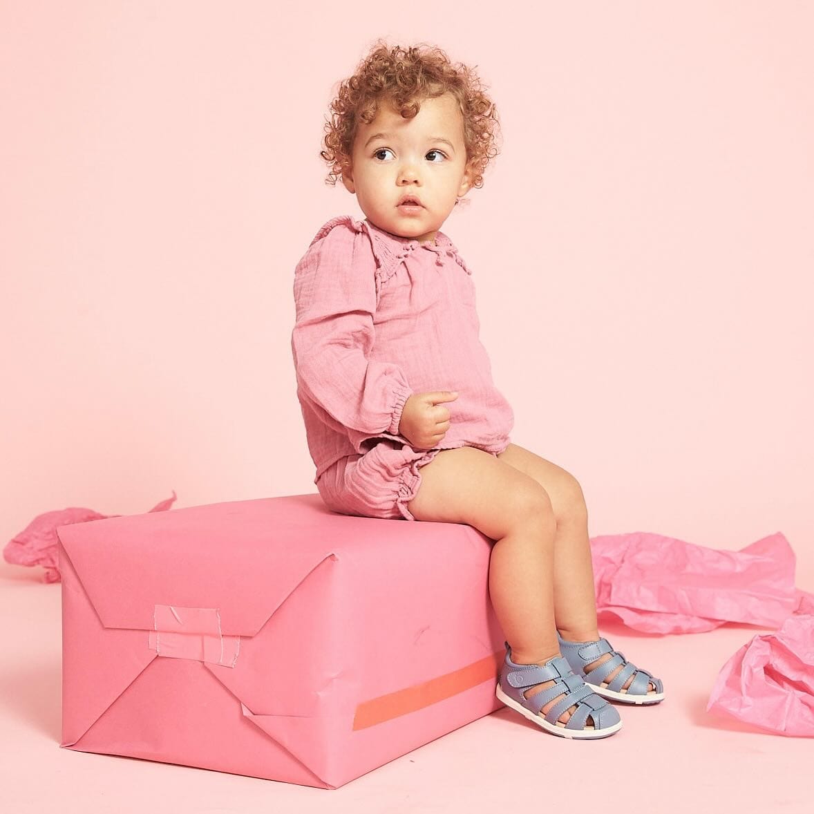 toddler in pink outfit and sandals