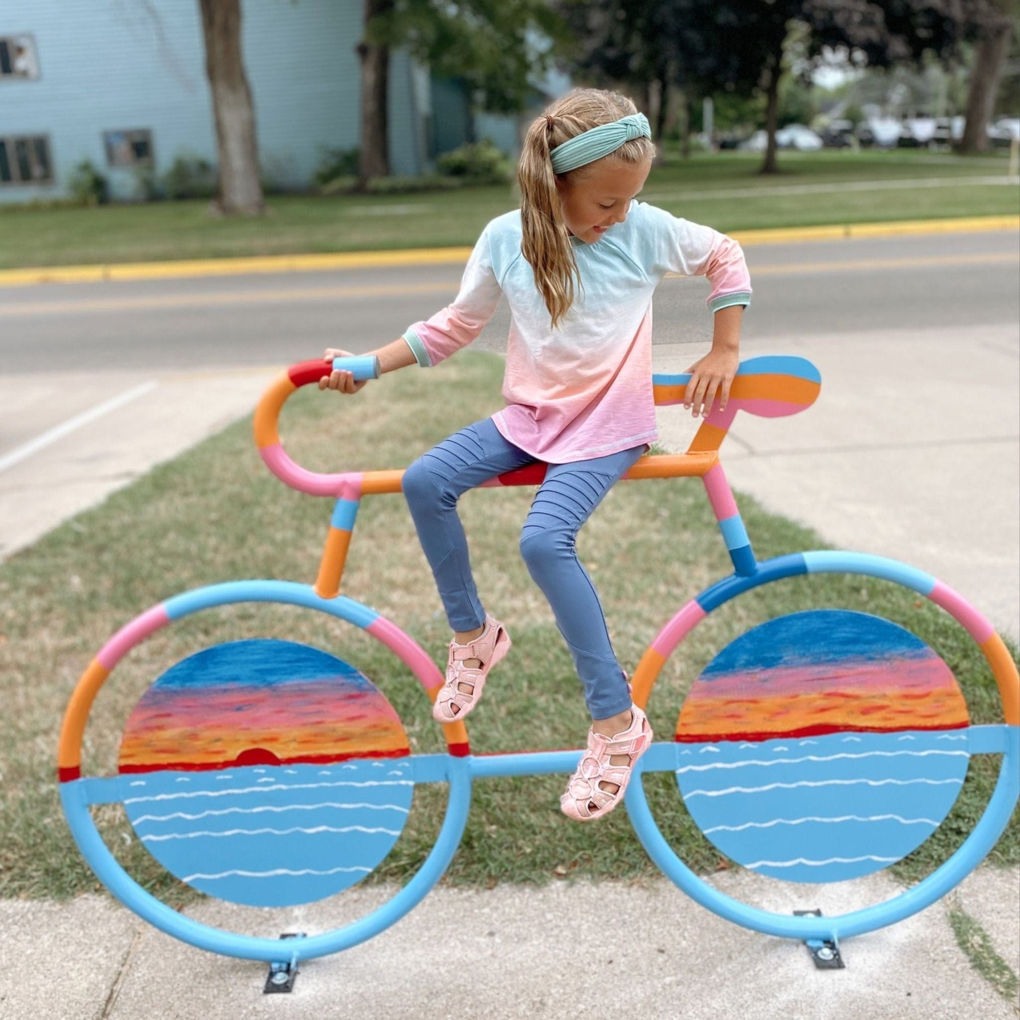 Girl on colorful bike sculpture
