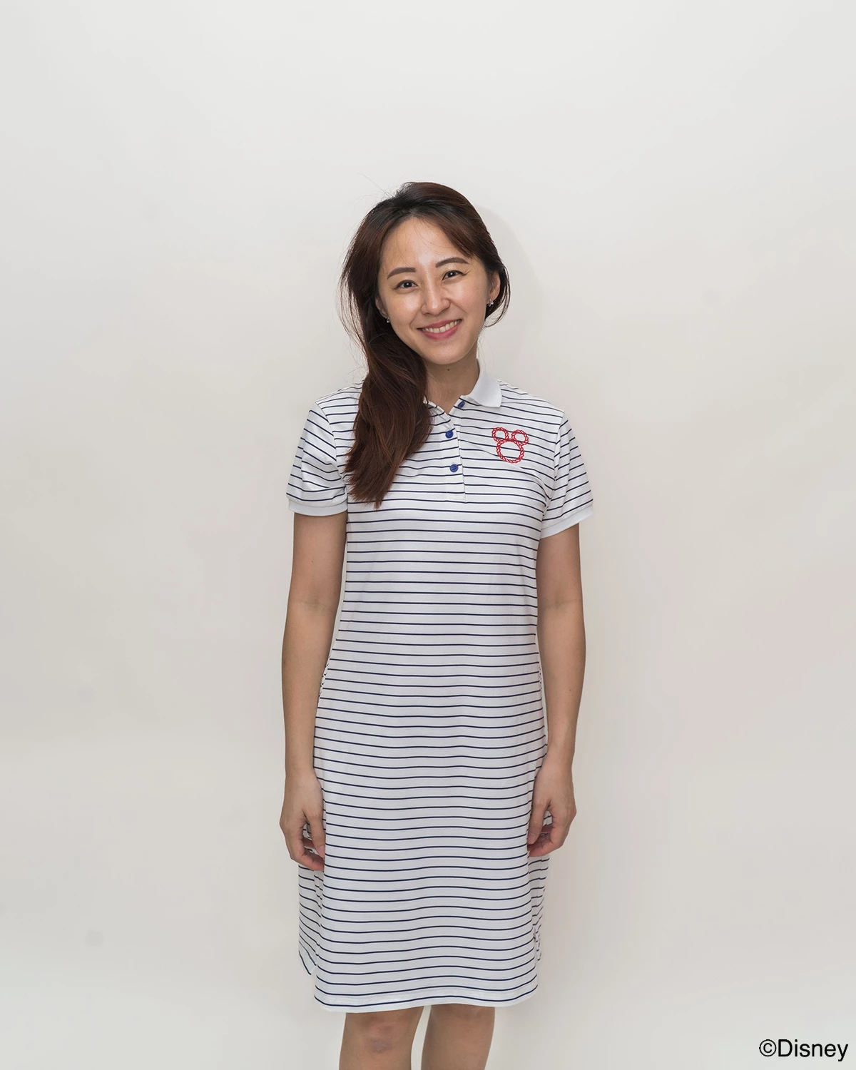 Woman wearing stripes sailor mickey polo dress with a logo on a white background