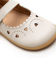 Close-up of the delicate scalloped edges and intricate heart laser cut-outs on the tapioca kids shoe.