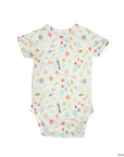 A short-sleeve baby bodysuit with an all-over whimsical print of Disney princesses, castles, and magical icons on a cream-colored background, shown flat against a white background.