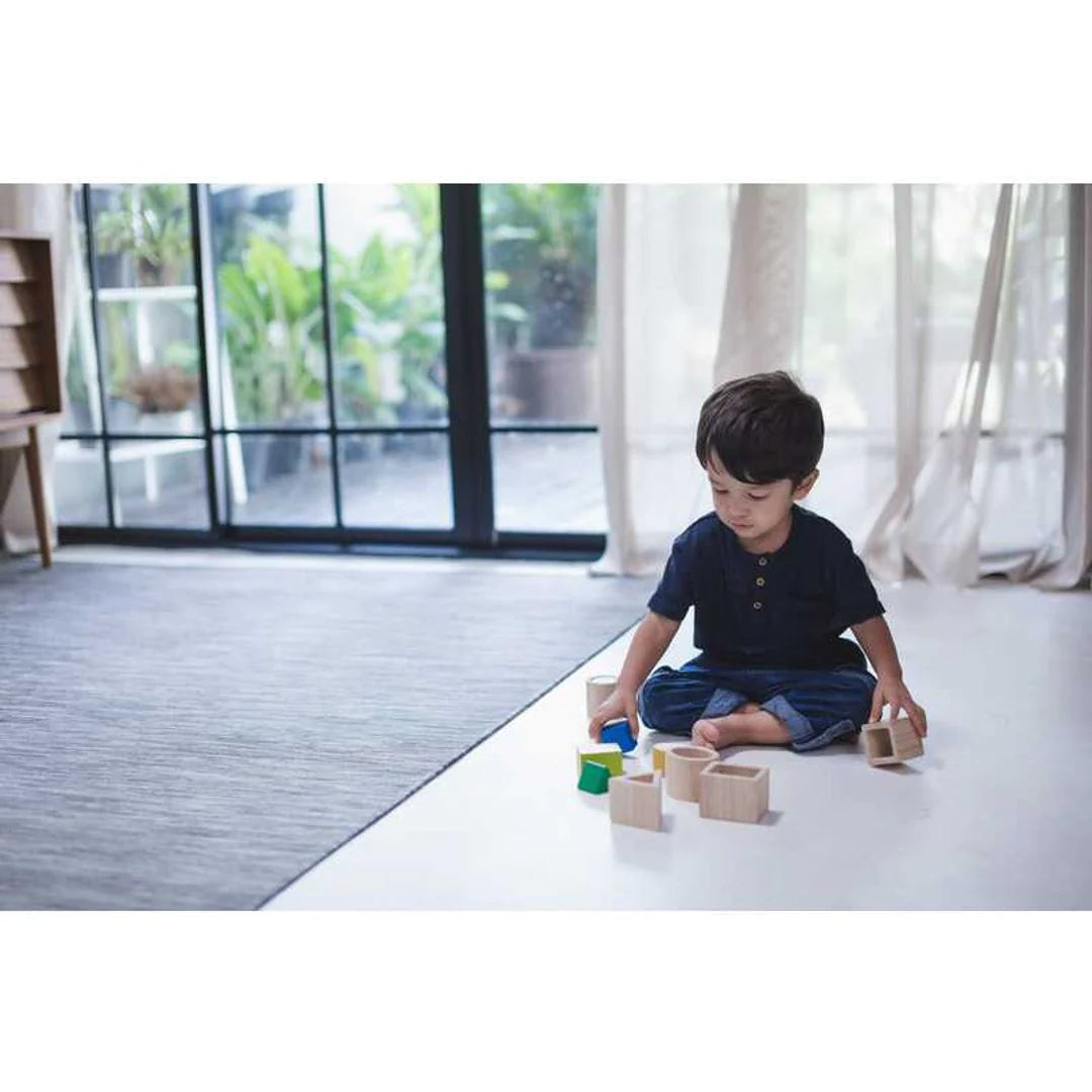 Child playing with PlanToys Geo Matching Blocks
